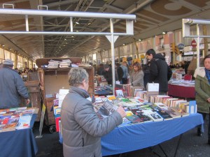 L' Olga montant la paradeta del diumenges al mercat amb el llibre de la Huelga de alquileres y el comité de defensa a la mà